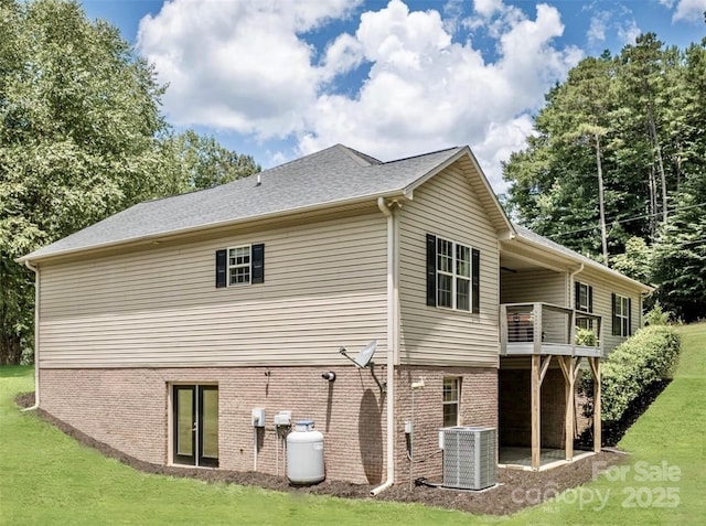 back of property featuring cooling unit, a lawn, and a balcony