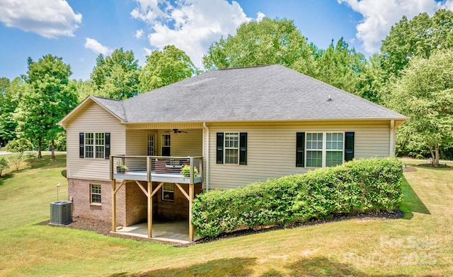 back of property with central AC unit, ceiling fan, and a lawn