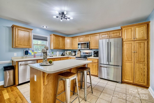 5692 Marblestone Dr, Granite Falls, NC 28630 - kitchen with appliances with stainless steel finishes, light countertops, a kitchen breakfast bar, a center island, and baseboards