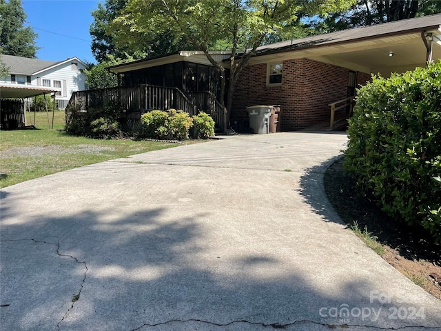 view of side of property featuring a lawn and a carport