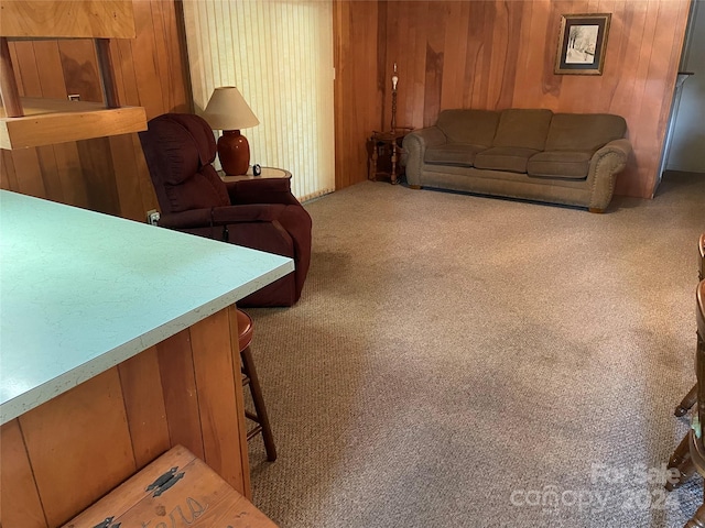 carpeted living room featuring wood walls