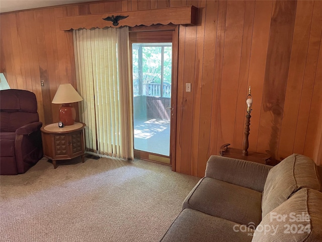 sitting room with carpet floors and wooden walls