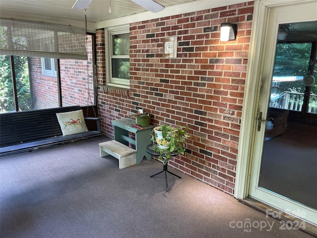 unfurnished sunroom with ceiling fan