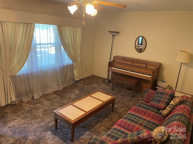 living room featuring ceiling fan and dark carpet