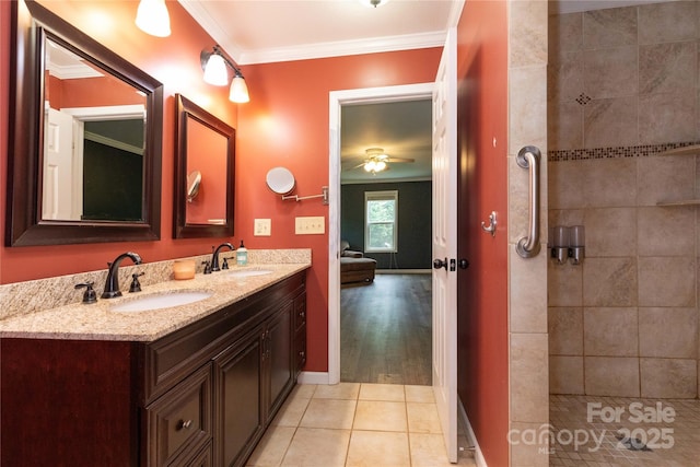 bathroom featuring tile patterned flooring, ornamental molding, vanity, tiled shower, and ceiling fan