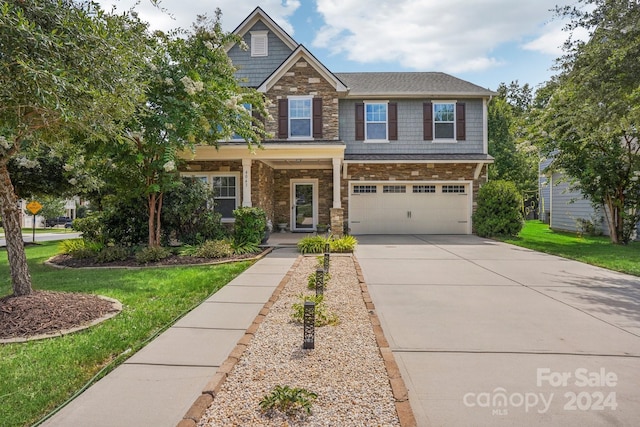 craftsman house featuring a garage and a front lawn