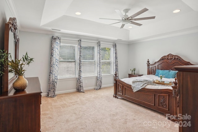 carpeted bedroom with a raised ceiling, ceiling fan, and crown molding