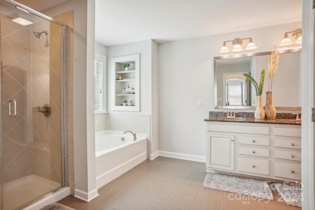 bathroom with a wealth of natural light, vanity, and shower with separate bathtub