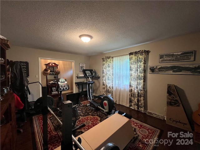 workout room featuring a textured ceiling