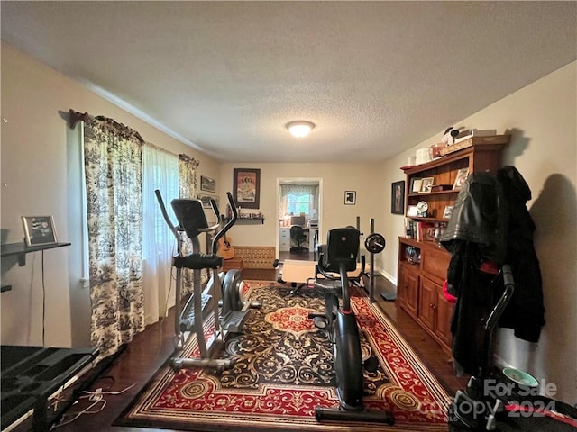 workout room with dark hardwood / wood-style flooring and a textured ceiling