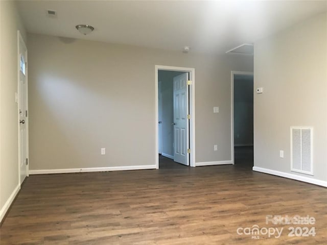 unfurnished room with dark hardwood / wood-style flooring