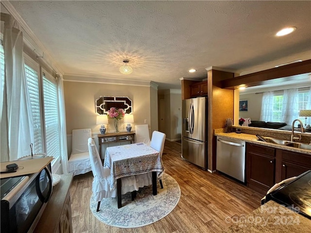 kitchen featuring stainless steel appliances, ornamental molding, dark hardwood / wood-style flooring, and sink