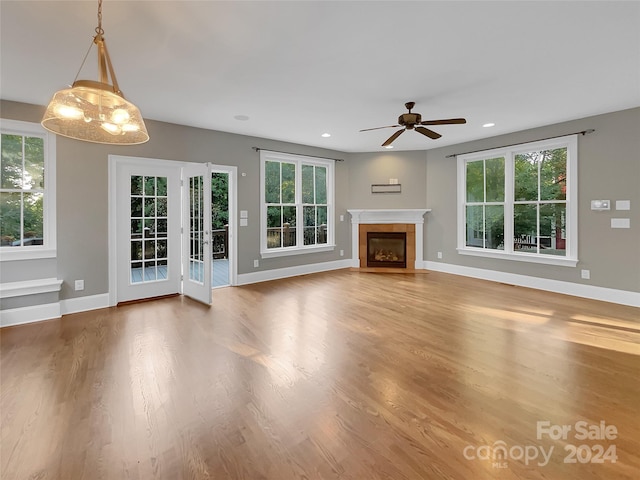 unfurnished living room featuring ceiling fan, plenty of natural light, and hardwood / wood-style floors