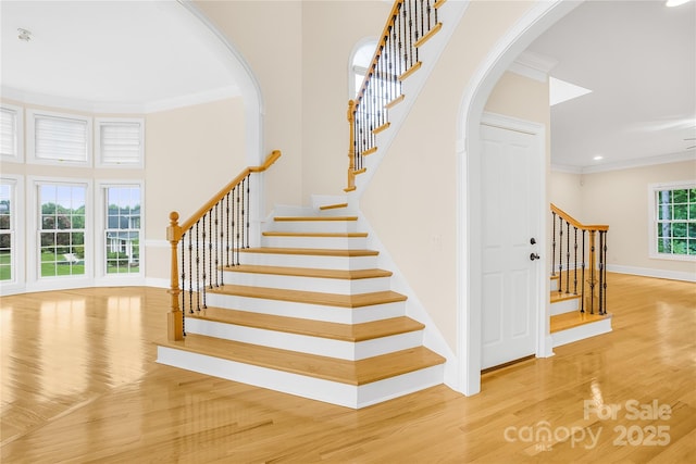 stairs featuring hardwood / wood-style floors and crown molding