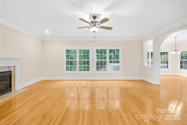 unfurnished living room with a wealth of natural light, light hardwood / wood-style flooring, crown molding, and a fireplace