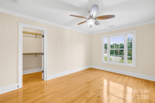 unfurnished bedroom with ceiling fan, hardwood / wood-style floors, a closet, and crown molding