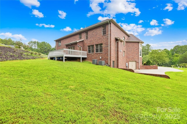 back of house with a deck, a yard, and central AC