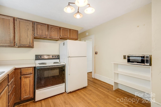 kitchen with white appliances and light hardwood / wood-style floors