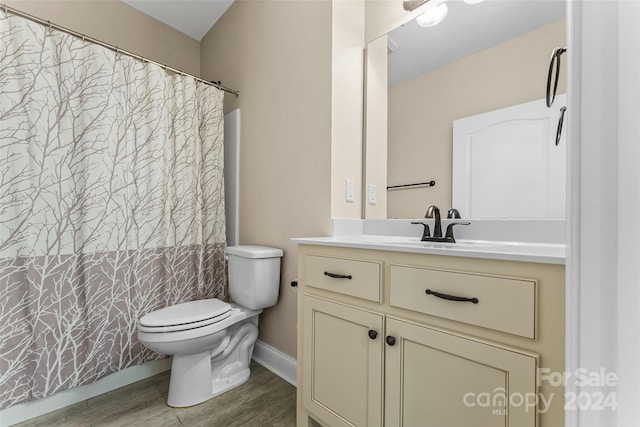 bathroom featuring toilet, hardwood / wood-style floors, vanity, and curtained shower