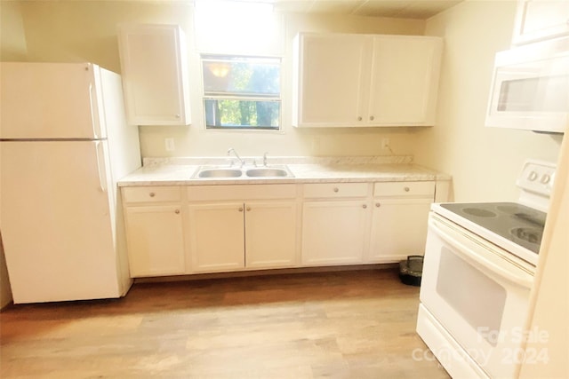 kitchen with white cabinetry, sink, white appliances, and light hardwood / wood-style flooring