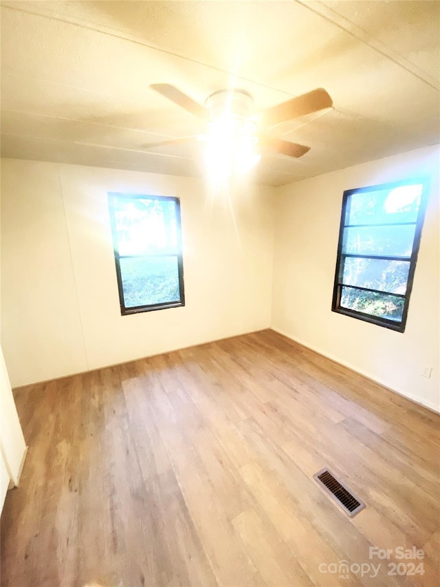 unfurnished room with ceiling fan and hardwood / wood-style floors