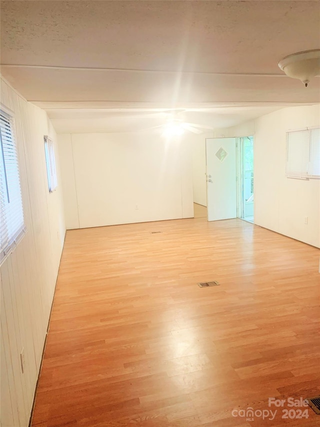 spare room with wood-type flooring and wood walls