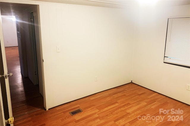 unfurnished room with hardwood / wood-style flooring