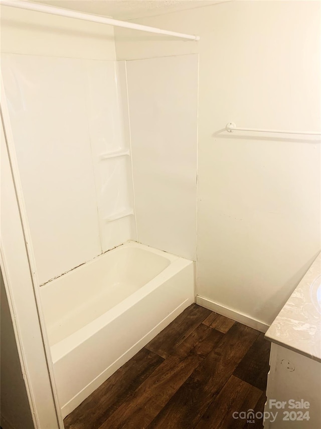 bathroom with hardwood / wood-style floors, vanity, and shower / washtub combination