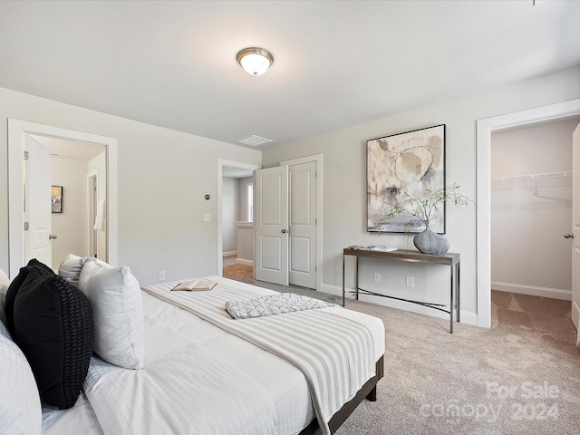 carpeted bedroom featuring a spacious closet and a closet