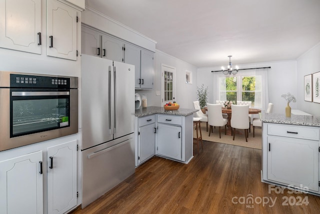 kitchen with white cabinetry, appliances with stainless steel finishes, dark hardwood / wood-style flooring, and light stone counters