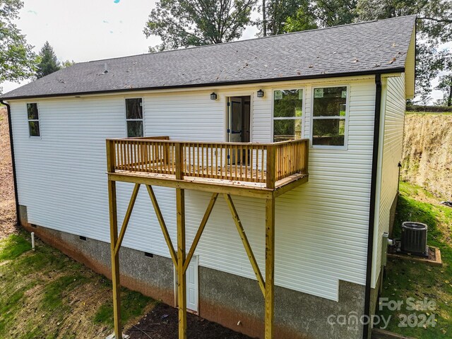 rear view of house with cooling unit and a deck