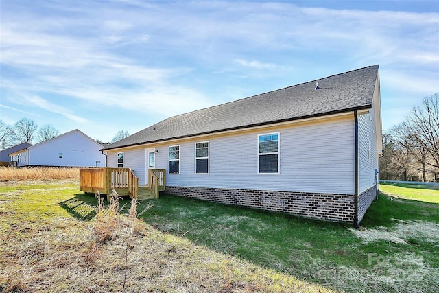 rear view of house with a deck and a lawn