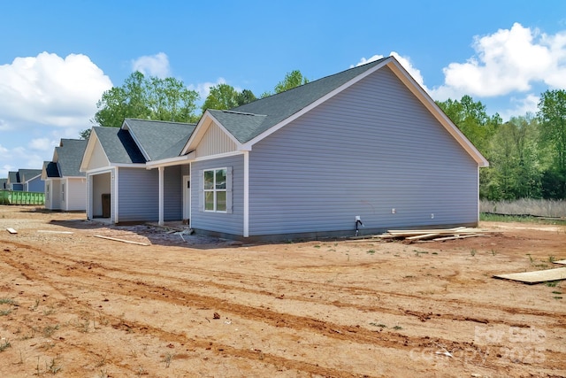 view of home's exterior featuring a garage and a shingled roof