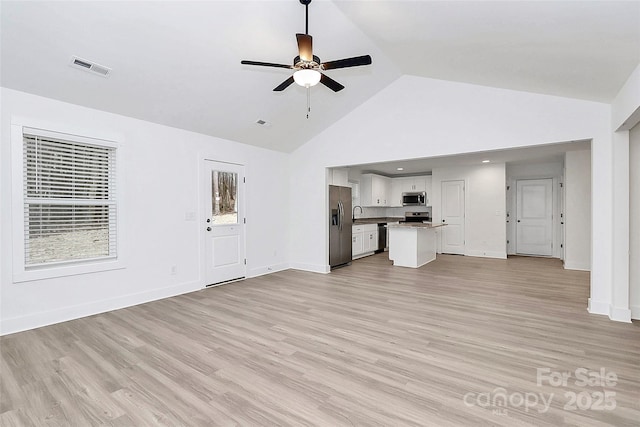 unfurnished living room featuring a ceiling fan, visible vents, high vaulted ceiling, and light wood-style flooring
