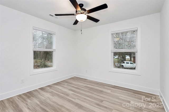 unfurnished room with baseboards, a ceiling fan, visible vents, and light wood-style flooring