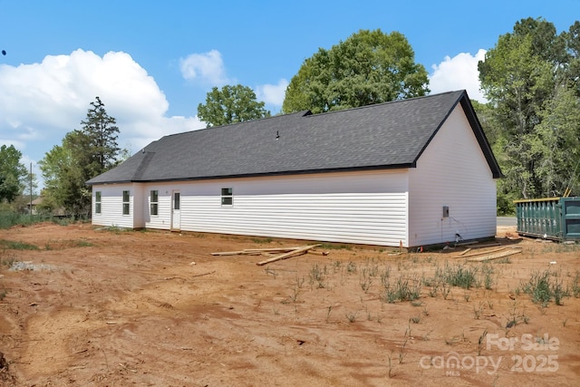 back of house featuring a shingled roof