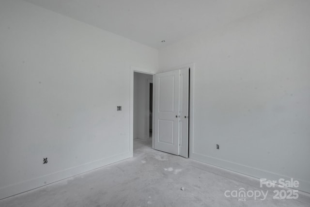 empty room with baseboards and concrete floors