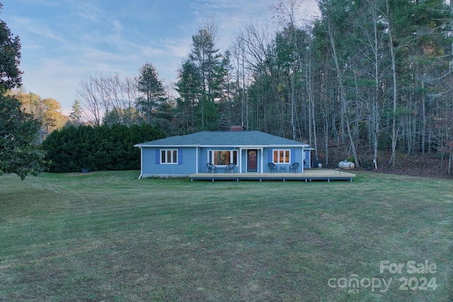 ranch-style home with a front lawn and a wooden deck