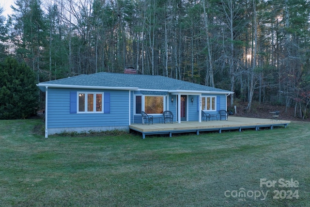 view of front facade featuring a wooden deck and a front yard