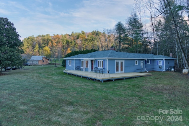 view of front of home featuring french doors, a front lawn, and a wooden deck