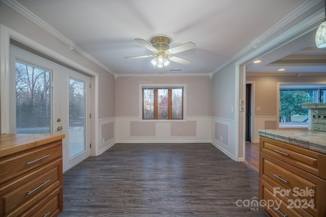 unfurnished dining area with dark hardwood / wood-style floors, crown molding, and a healthy amount of sunlight