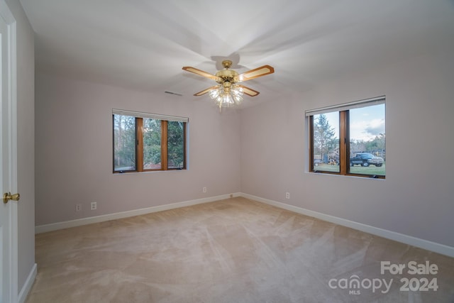 carpeted empty room featuring ceiling fan