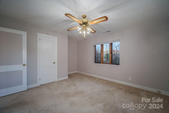 unfurnished room featuring ceiling fan and light carpet