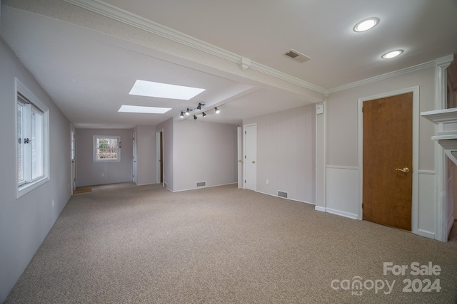 carpeted empty room with crown molding and a skylight