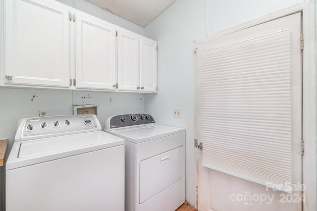 washroom featuring cabinets and washing machine and clothes dryer