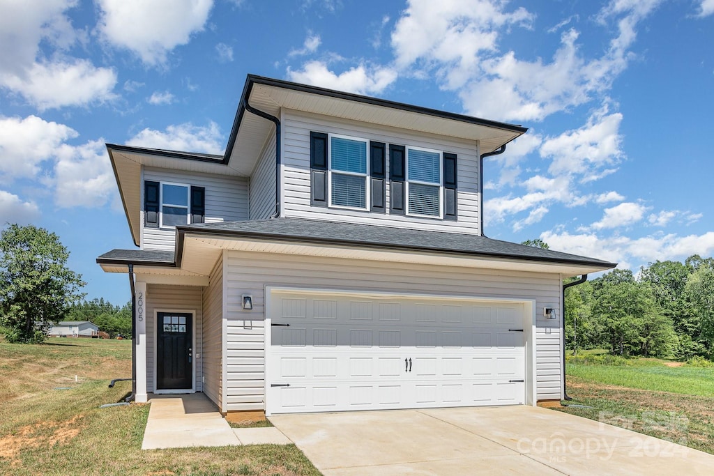 view of front of home with a front yard and a garage