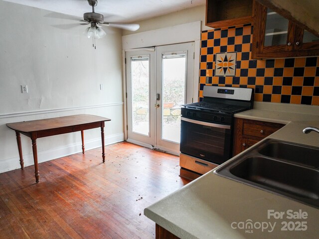 kitchen featuring sink, french doors, hardwood / wood-style floors, ceiling fan, and gas stove