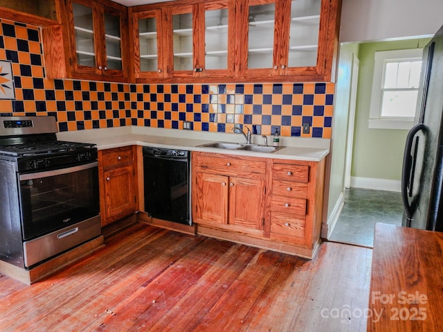 kitchen featuring gas stove, dark wood-type flooring, sink, black dishwasher, and backsplash