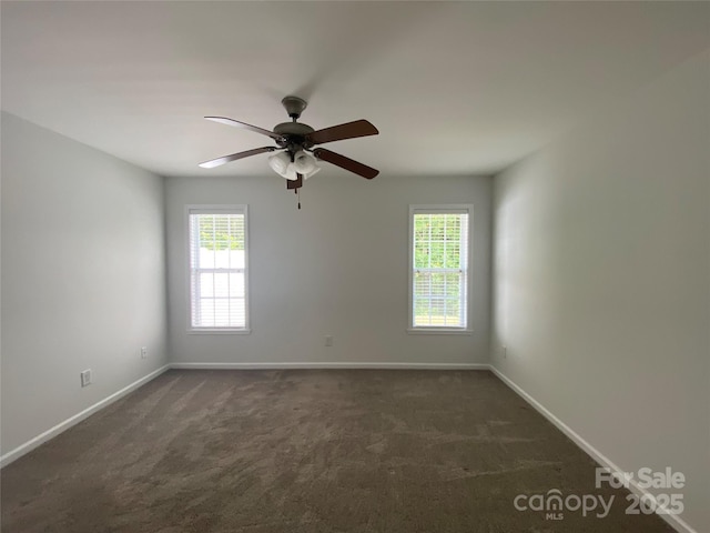 carpeted spare room featuring ceiling fan and a wealth of natural light