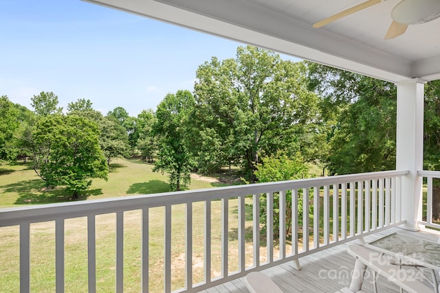 wooden deck with ceiling fan and a lawn